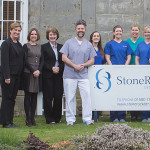 StoneRock staff standing behind sign